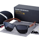 Black Walnut sunglasses with black lenses in front of case, cleaning cloth and pag