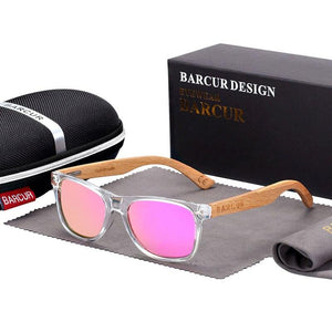 Children's polarized sunglasses with bamboo arms and pink lenses in front of hard case, bag and cleaning cloth